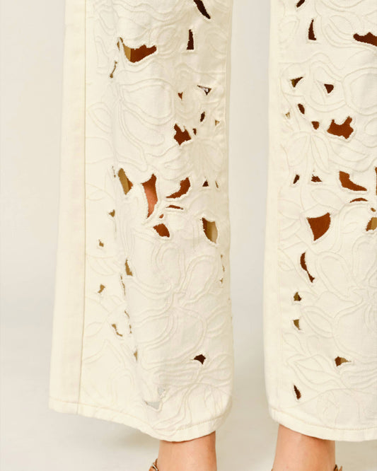 White pants with brown leaf patterns on a light gray background