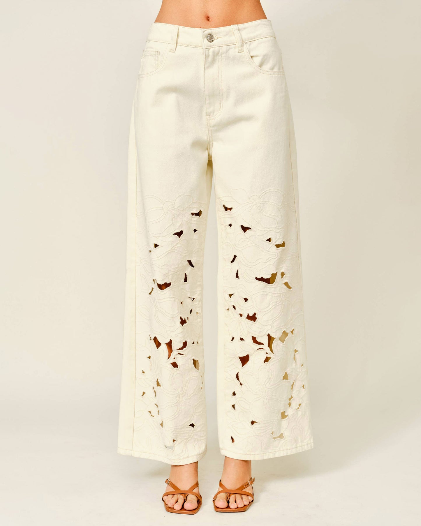 White pants with butterfly pattern worn by a person on a white background