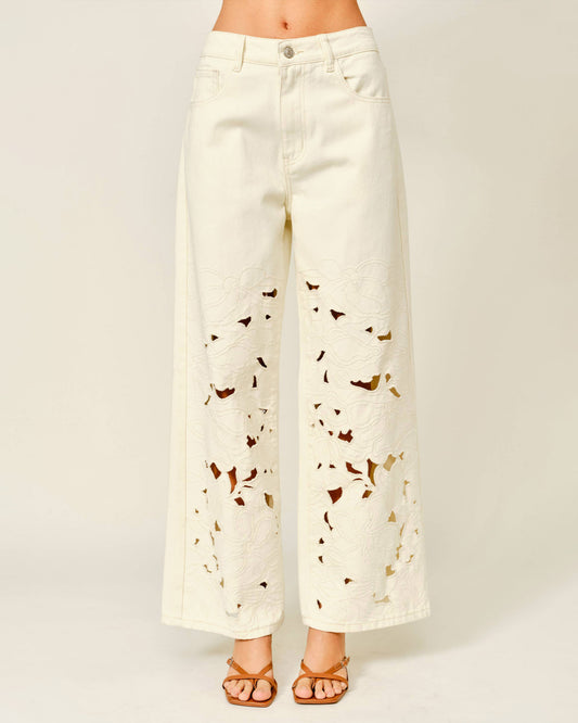 White pants with butterfly pattern worn by a person on a white background
