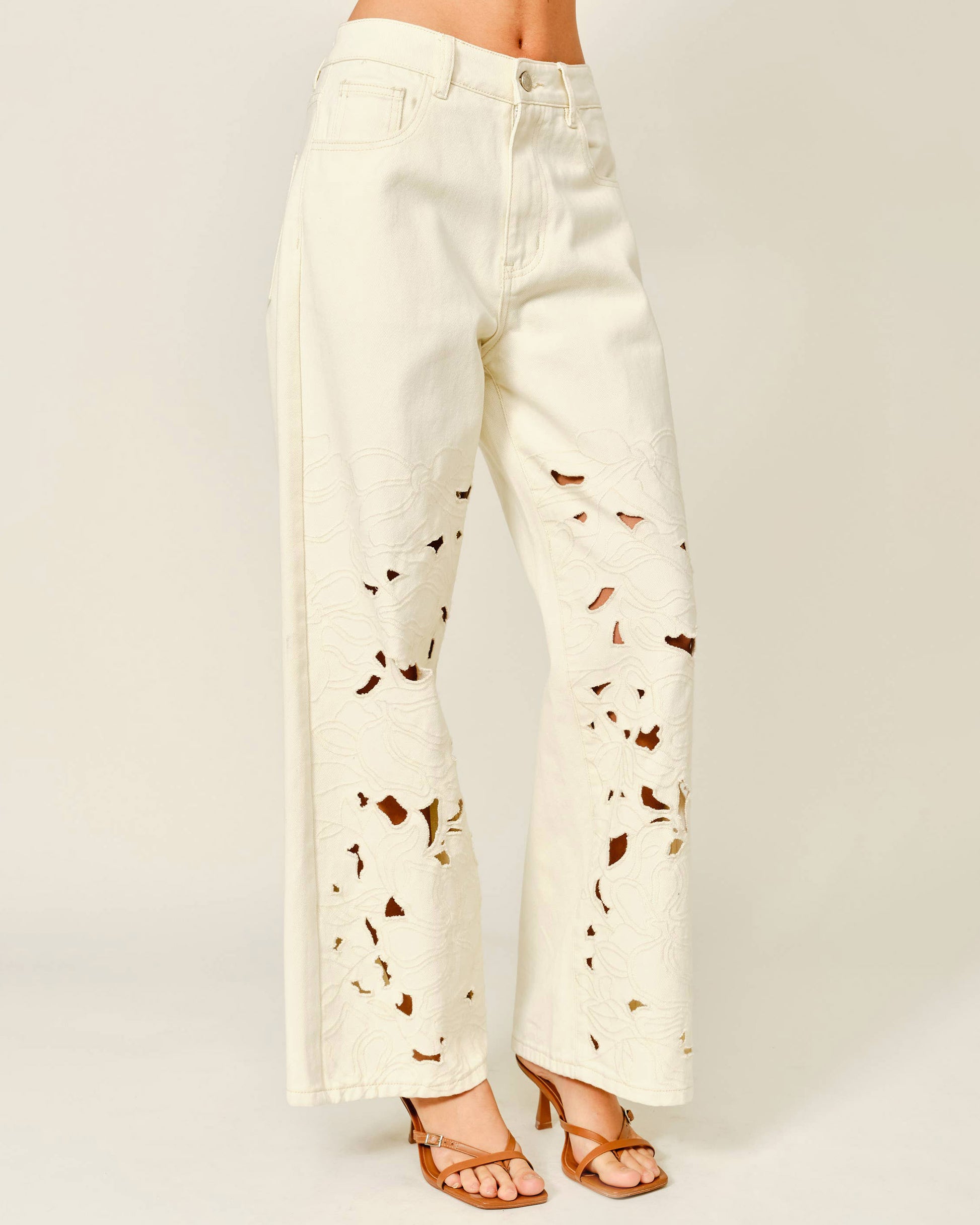 White pants with brown abstract patterns on a plain background