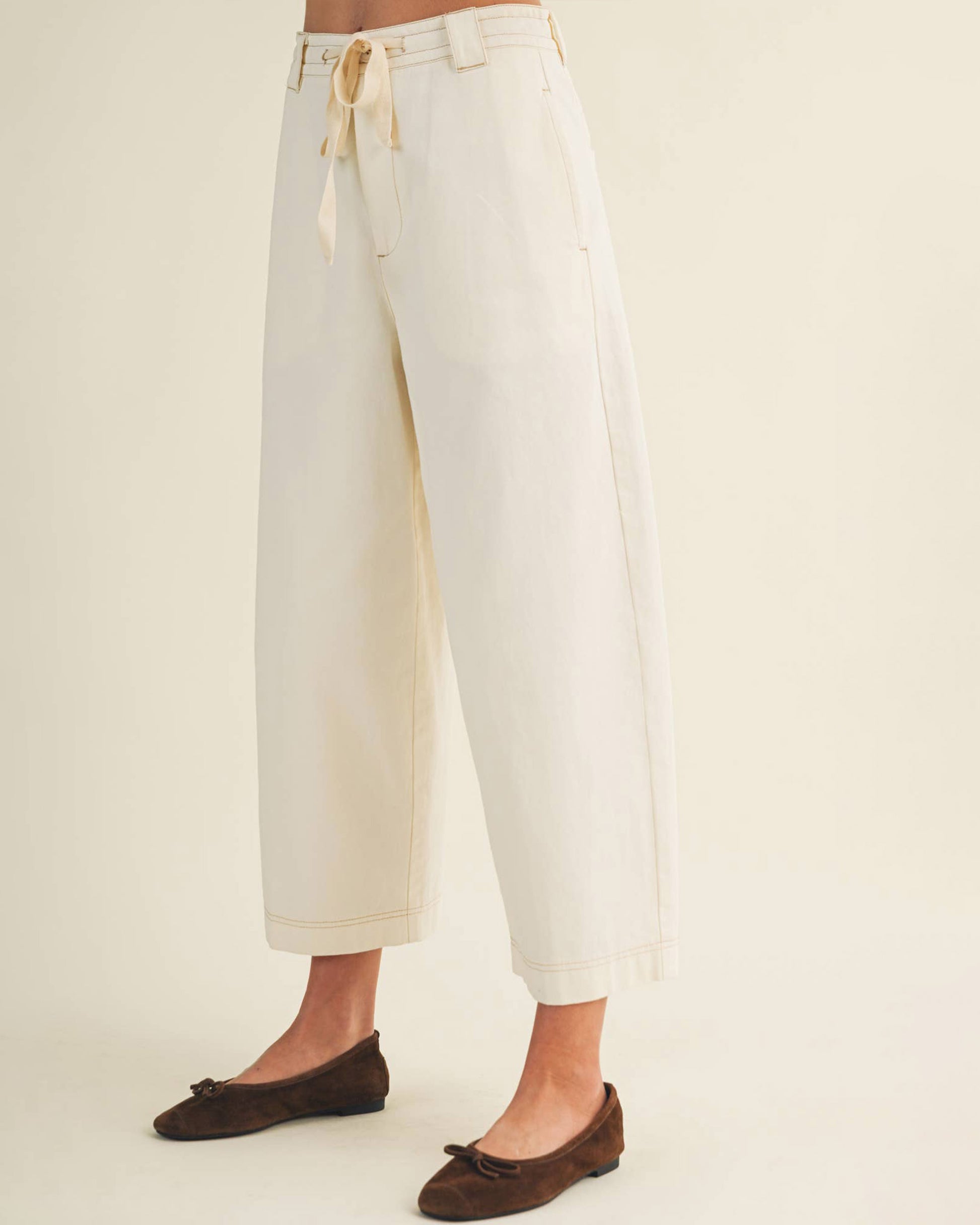 White pants worn by a person on a plain background