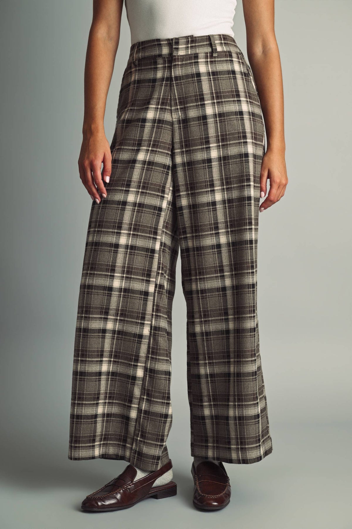Women's brown, black, and beige plaid high-waisted pants with a tailored wide leg silhouette and fitted waistband.