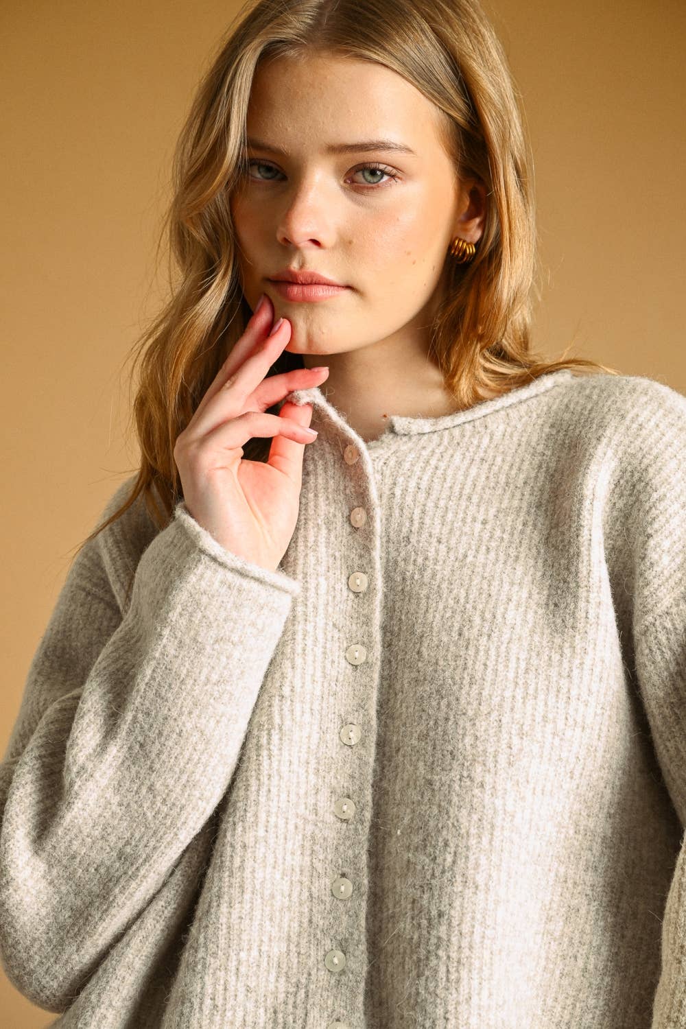 Women's grey ribbed knit cardigan sweater featuring pearl-like front buttons, a round neckline, and relaxed fit.
